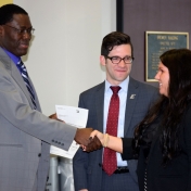 Tammy Peyton from Novelis presents check to Tom Otieno as Andrew Polter watches