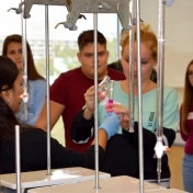 Madison Southern student assists Dr. Dasari by pouring liquid into test tube.