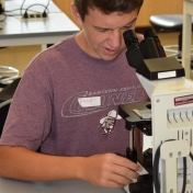 Model Lab student look at cells through a microscope