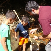 Stephen Richter shows children a rock at the Creek Crawl