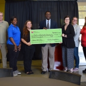 Dr. Tom Otieno and faculty working at STEM camp pose with Novelis reps