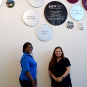 Monica Johnson and Tammy Peyton from Novelis stand in front of recognition wall